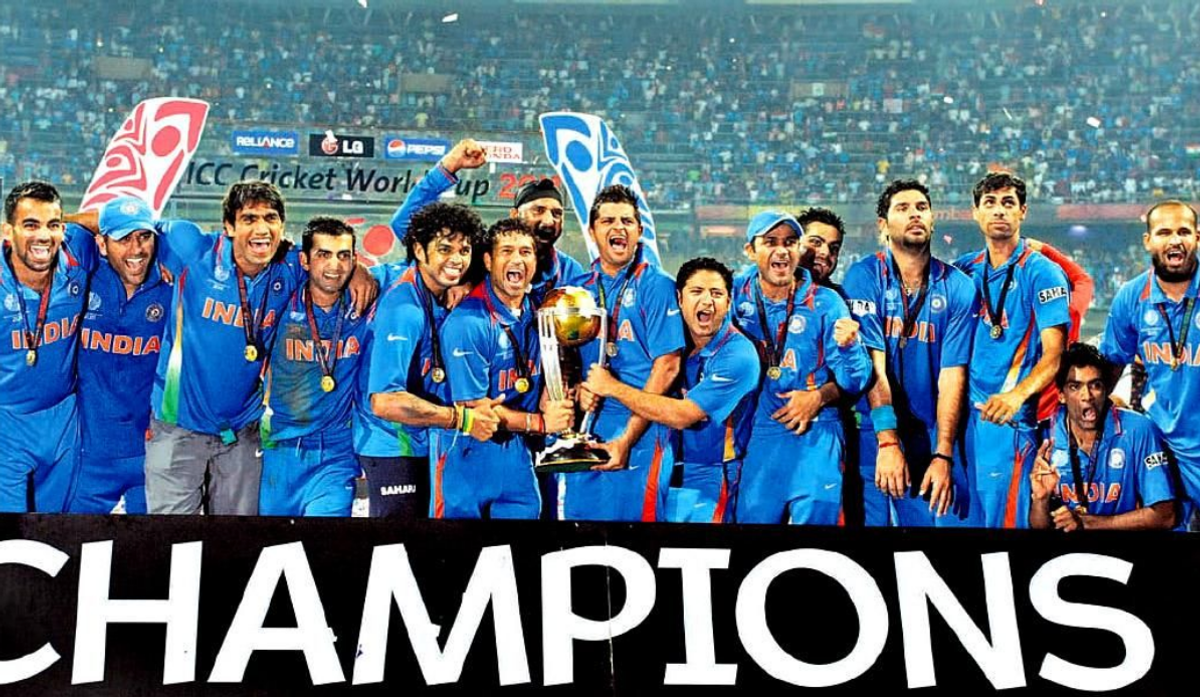 Picture of the Indian cricket team celebrating with their 2011 World Cup trophy, the word "CHAMPIONS" at the bottom of the image