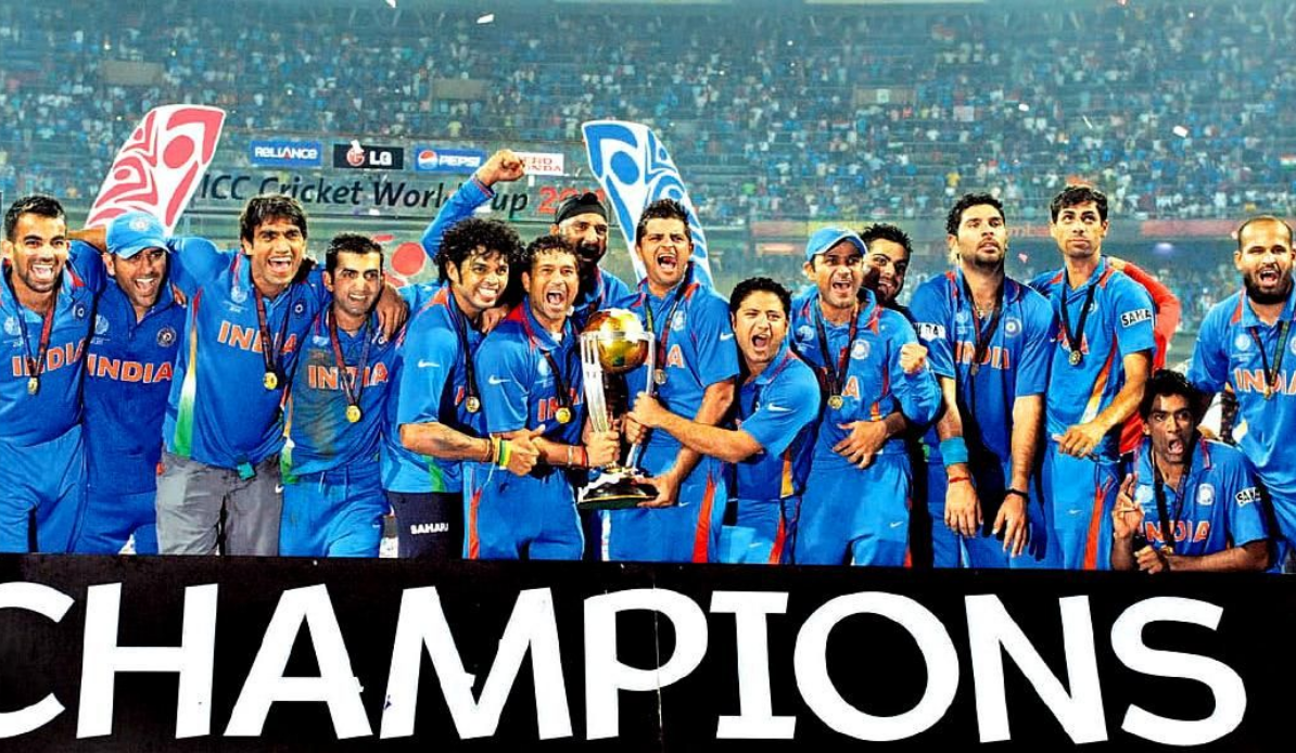 Picture of the Indian cricket team celebrating with their 2011 World Cup trophy, the word "CHAMPIONS" at the bottom of the image