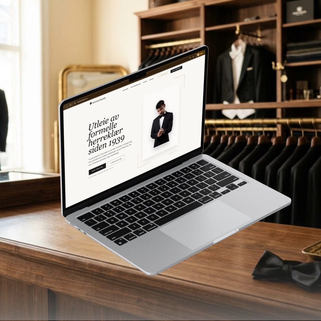 Festantrekk sin nettside vist på MacBook i et klassisk herregarderobe-atelier