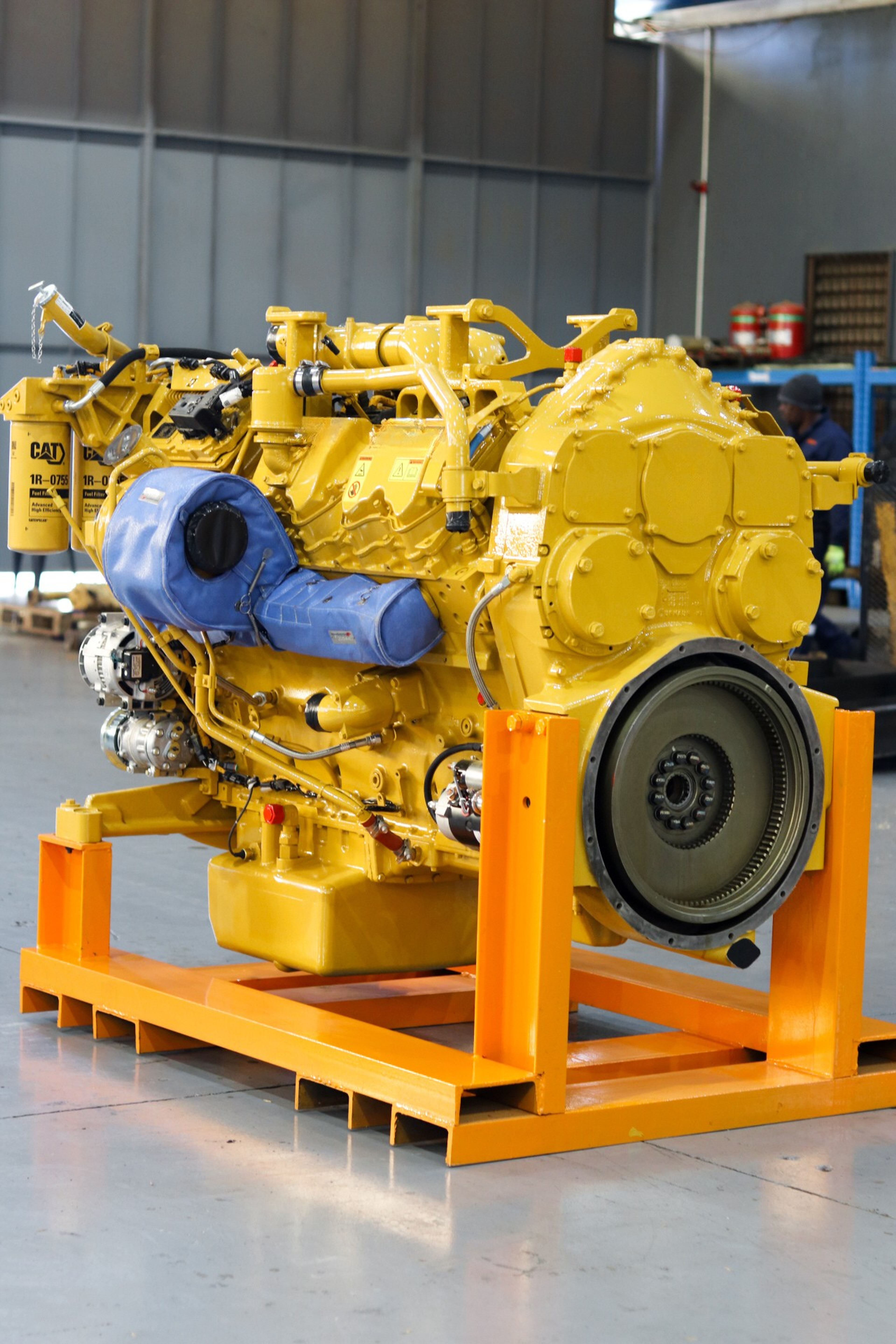 a yellow cat engine sits on a yellow stand