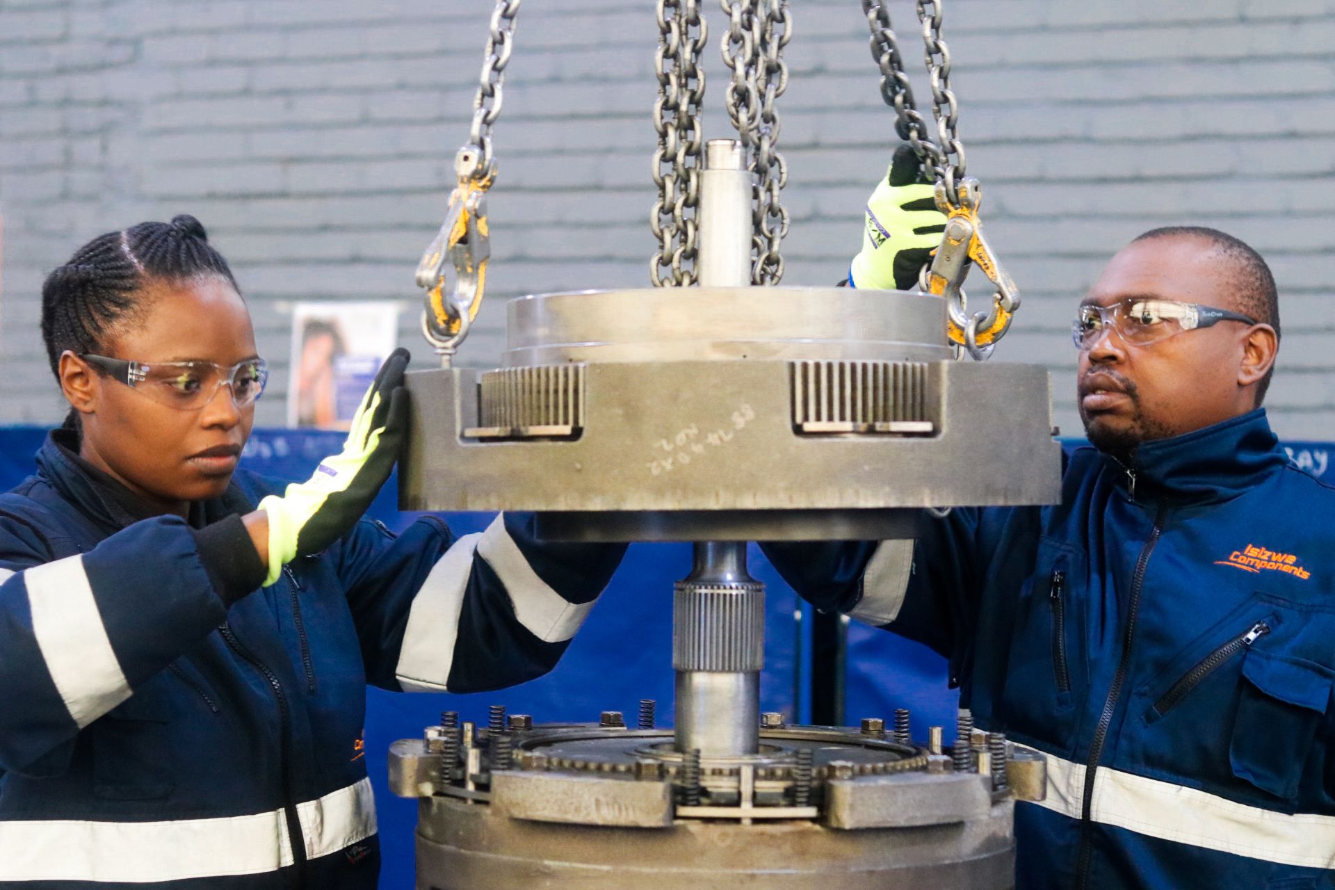a man and a woman are working on a machine in a factory .