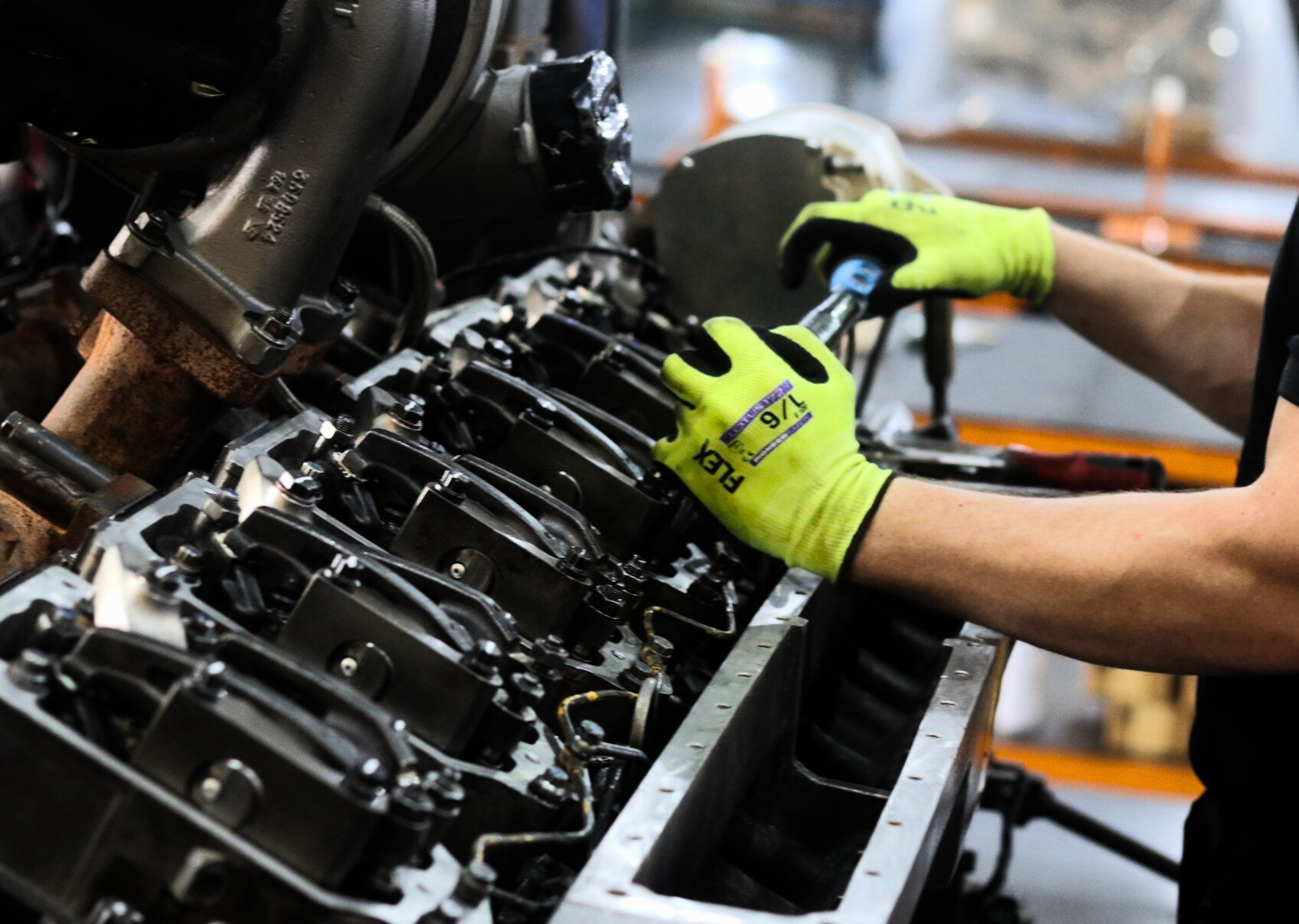 a man wearing a pair of flex gloves works on a machine