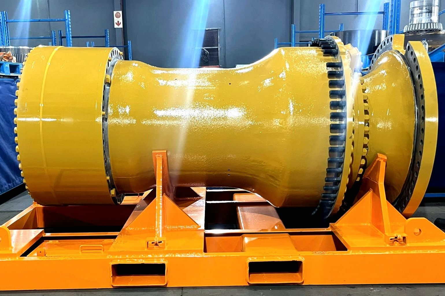 a large yellow wheel station is sitting on top of a yellow pallet in a warehouse .