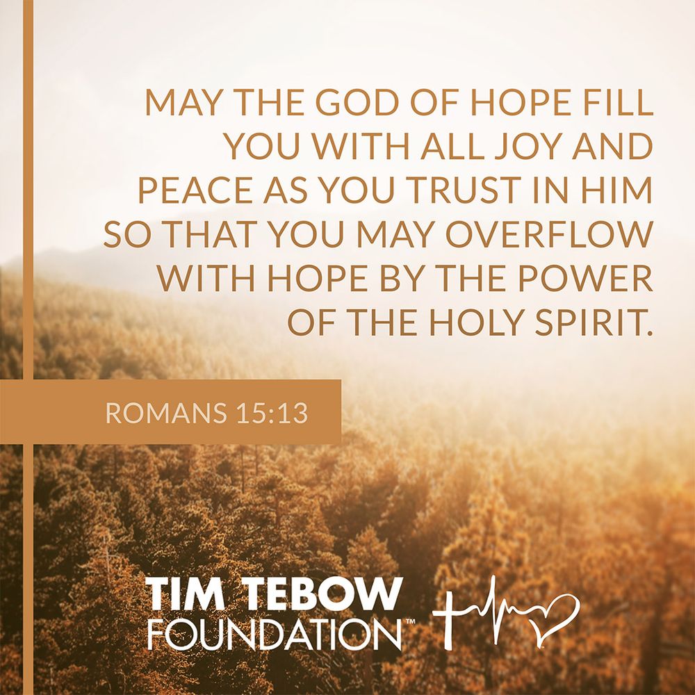 Tim Tebow Foundation scripture graphic with Romans 15:13 over an autumn forest
