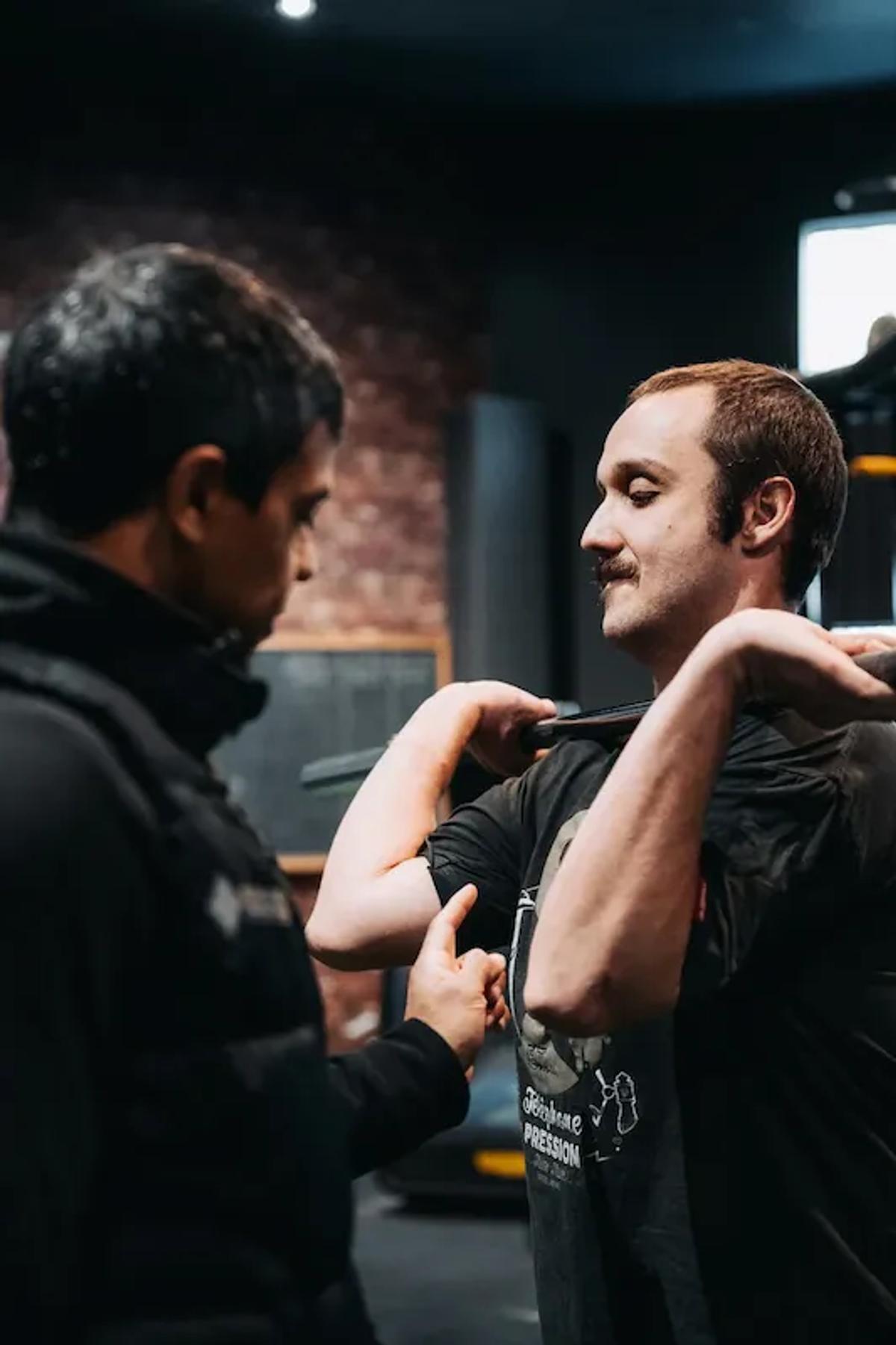 Coach helping a member with front squat form