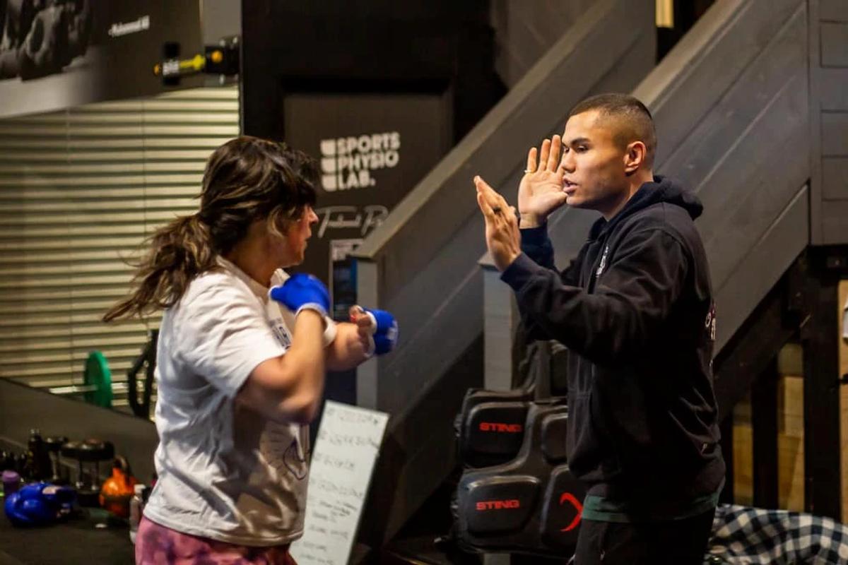 Coach guiding a member through boxing drills