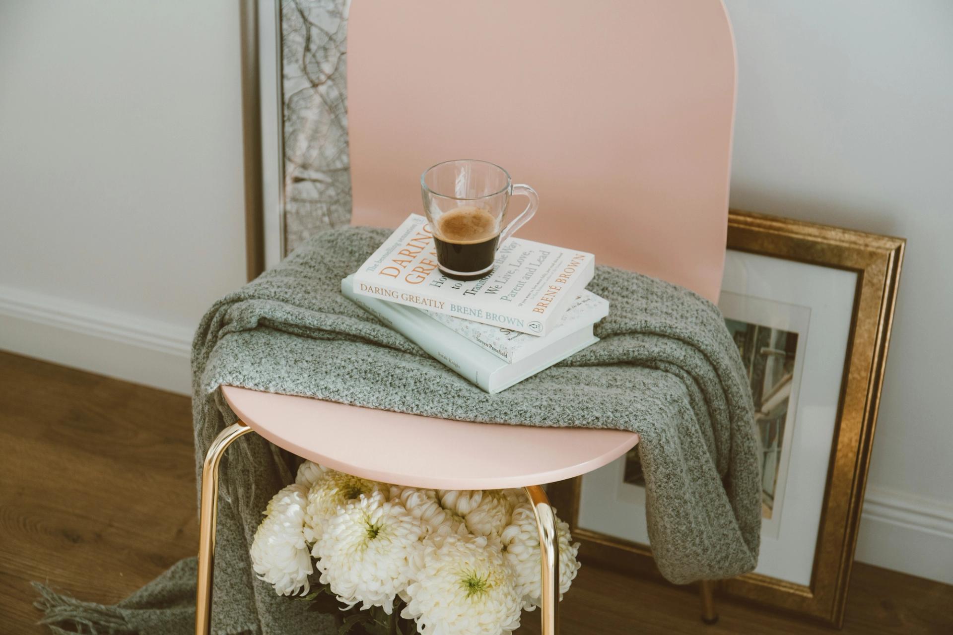 side table with a blanket and some books and a mug if coffee on top of it