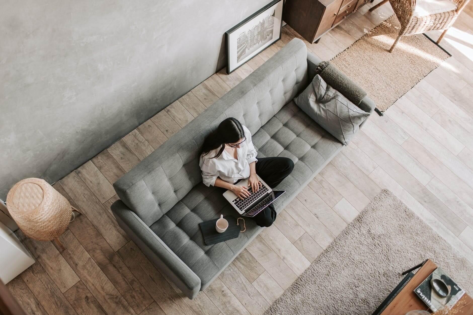 Woman working on her laptop on the sofa