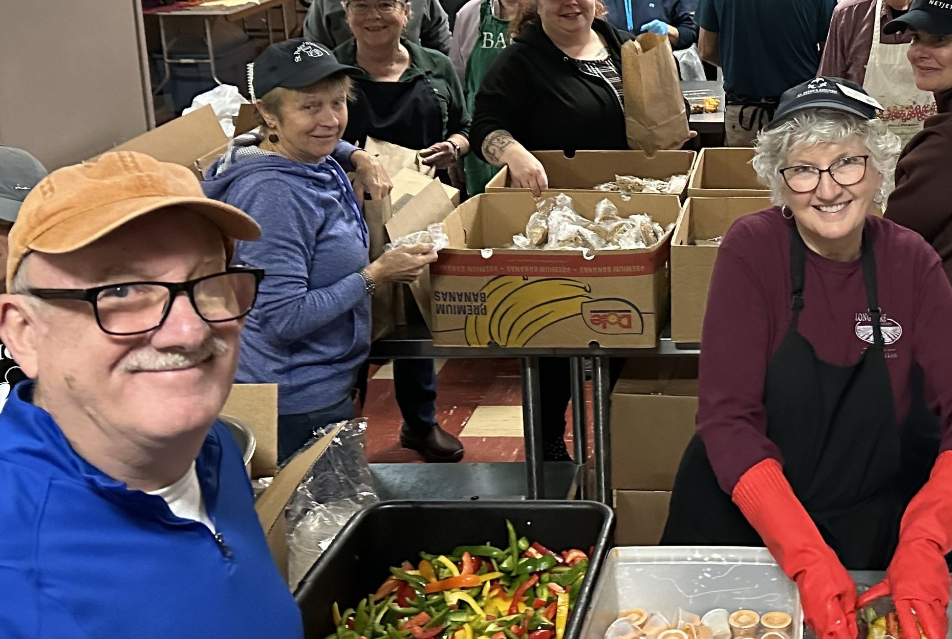 Many smiling and busy volunteers prepping for Thanksgiving dinner
