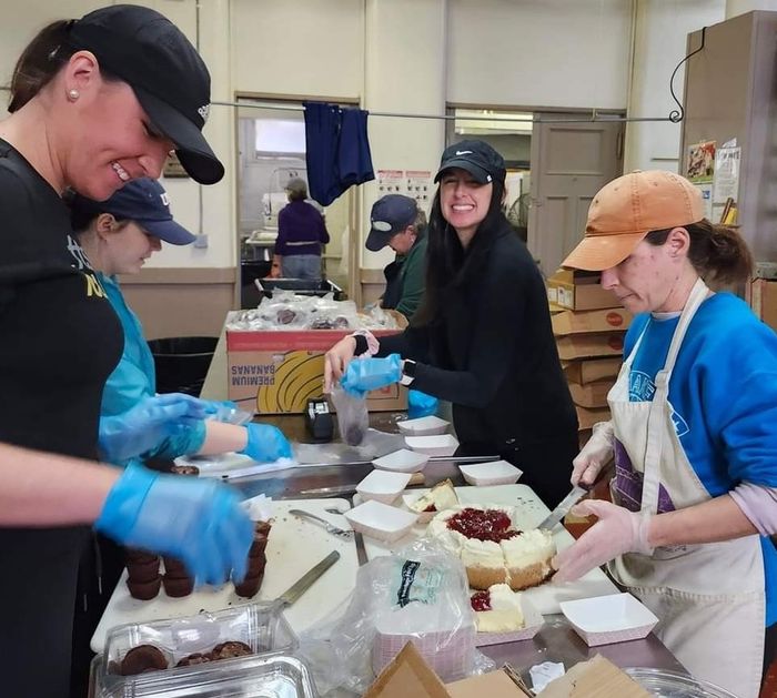 Volunteers prepping at counter with blue gloves