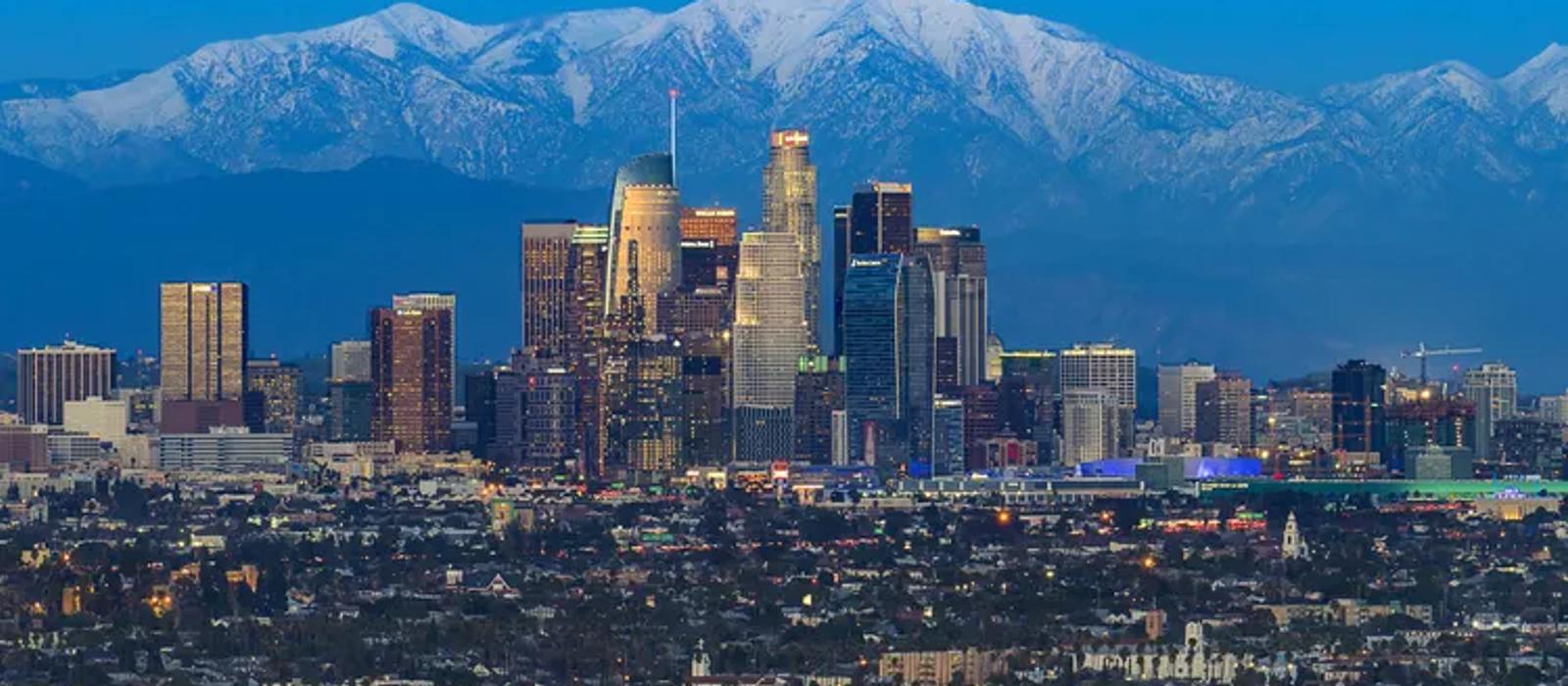 Los Angeles skyline with snow-capped San Gabriel Mountains at dusk