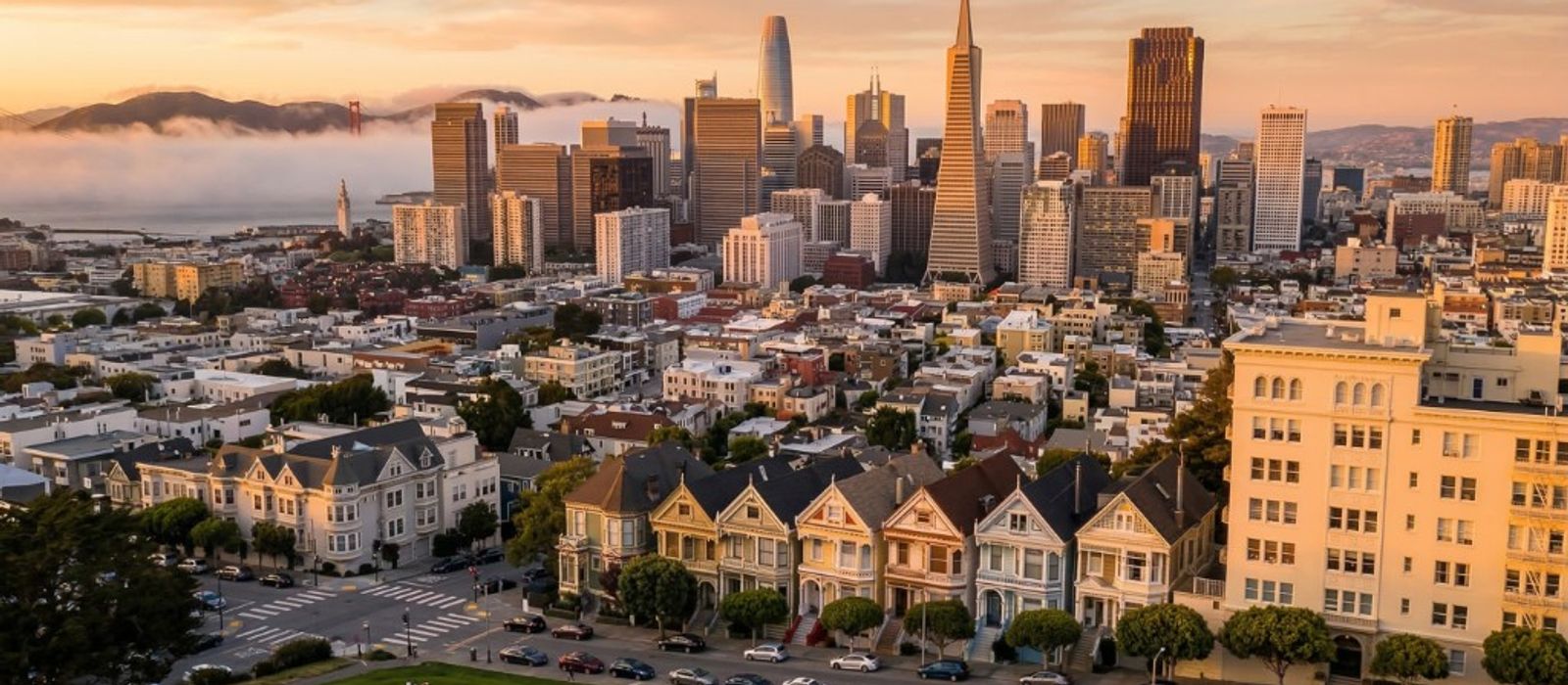 Aerial view of San Francisco Painted Ladies with city skyline at golden hour