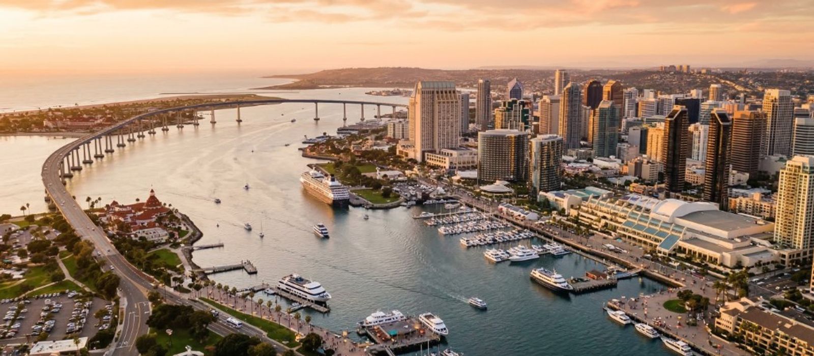 Aerial view of San Diego skyline and harbor with Coronado Bridge at golden hour