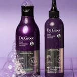 Two purple Dr. Groot scalp revitalizing solution bottles, one a shampoo with bubbles and one a treatment bottle with water droplets.