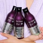 Model holding Dr. Groot hair thickening and scalp care products.