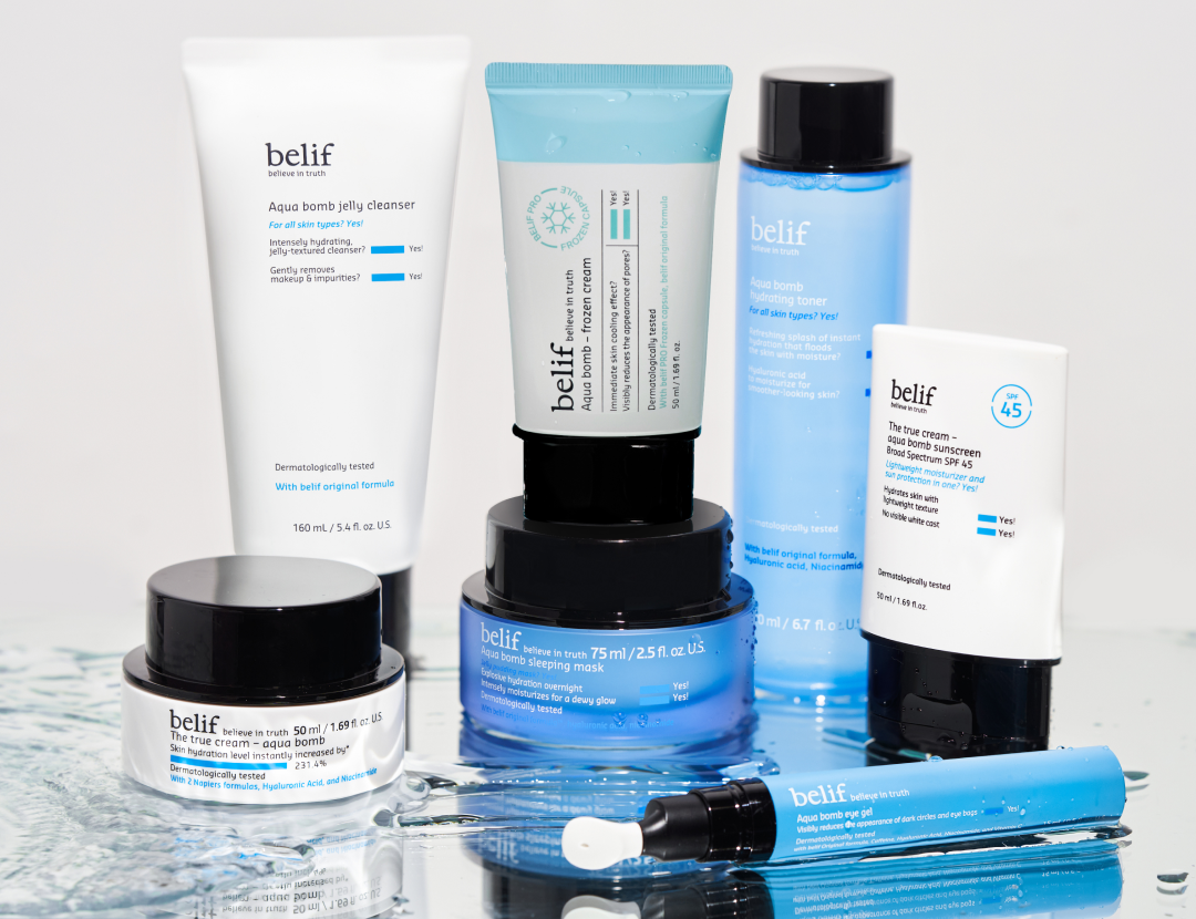Various Belif Aqua Bomb skincare products on a wet, reflective surface.
