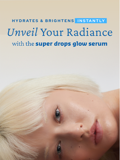 Close-up of a woman with short, blonde hair lying down with a visible eye and cheek. Text overlay reads: "Hydrates & Brightens Instantly. Unveil Your Radiance with the super drops glow serum.