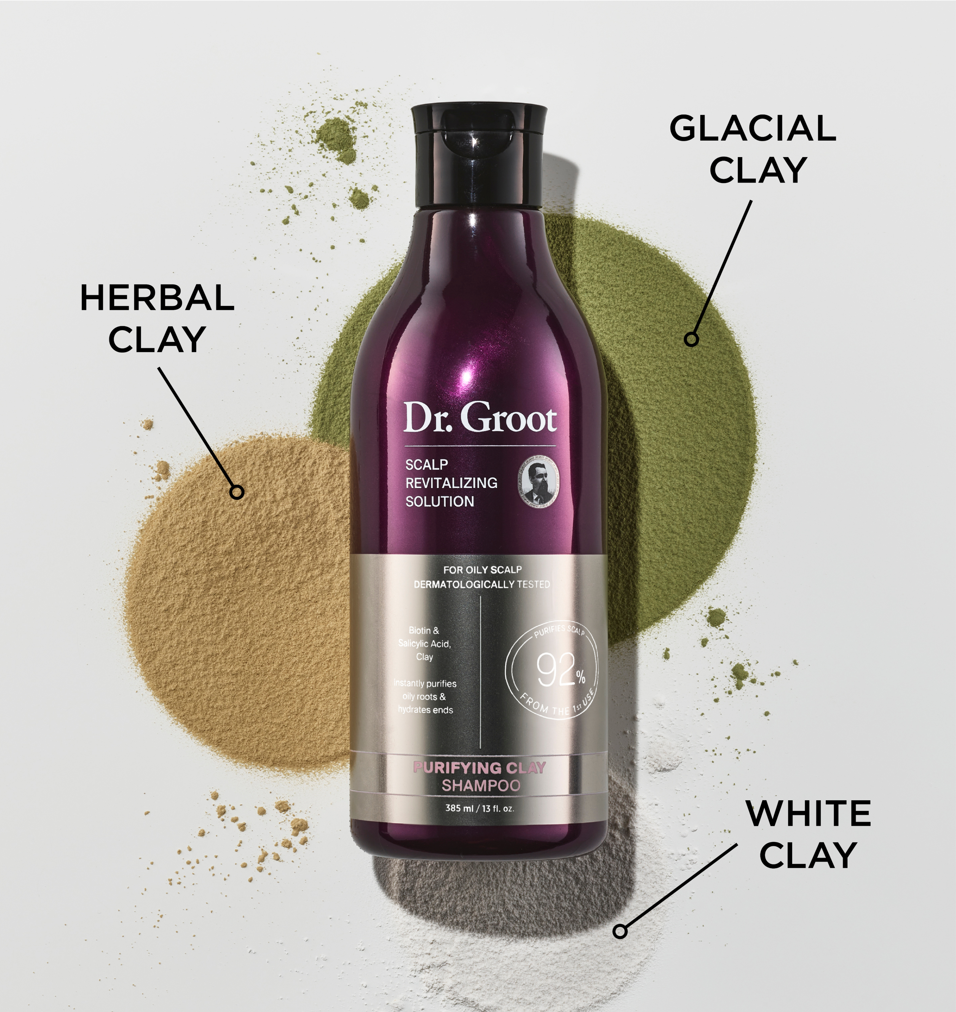 A bottle of Dr. Groot Purifying Clay Shampoo rests on a spread of glacial clay, herbal clay, and white clay.