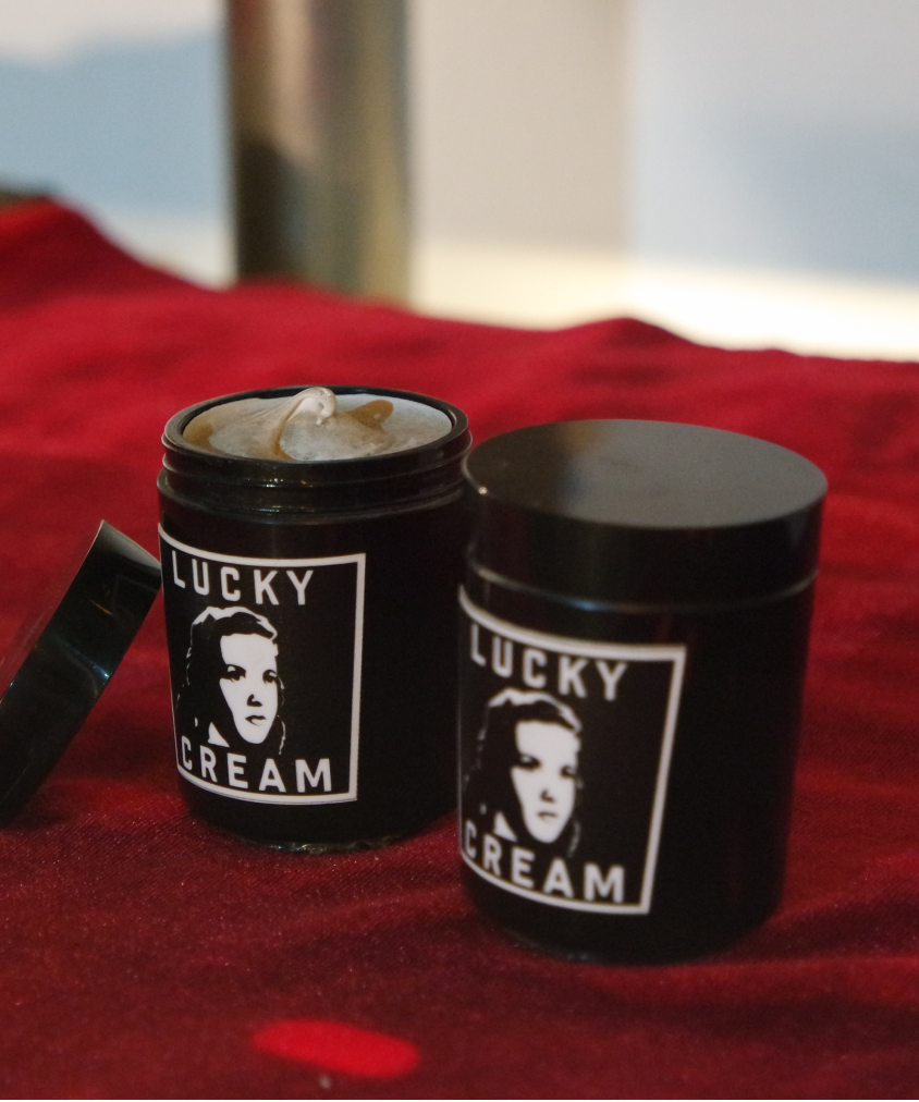 Two jars of a popular face moisturizer called Lucky Cream are on display, with one jar open to display the cream inside.