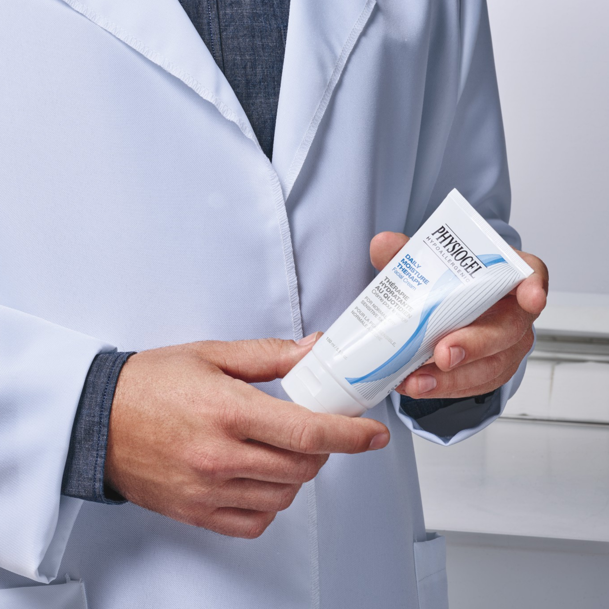 A doctor holding a tube of Physiogel Daily Moisture Therapy Intensive Cream