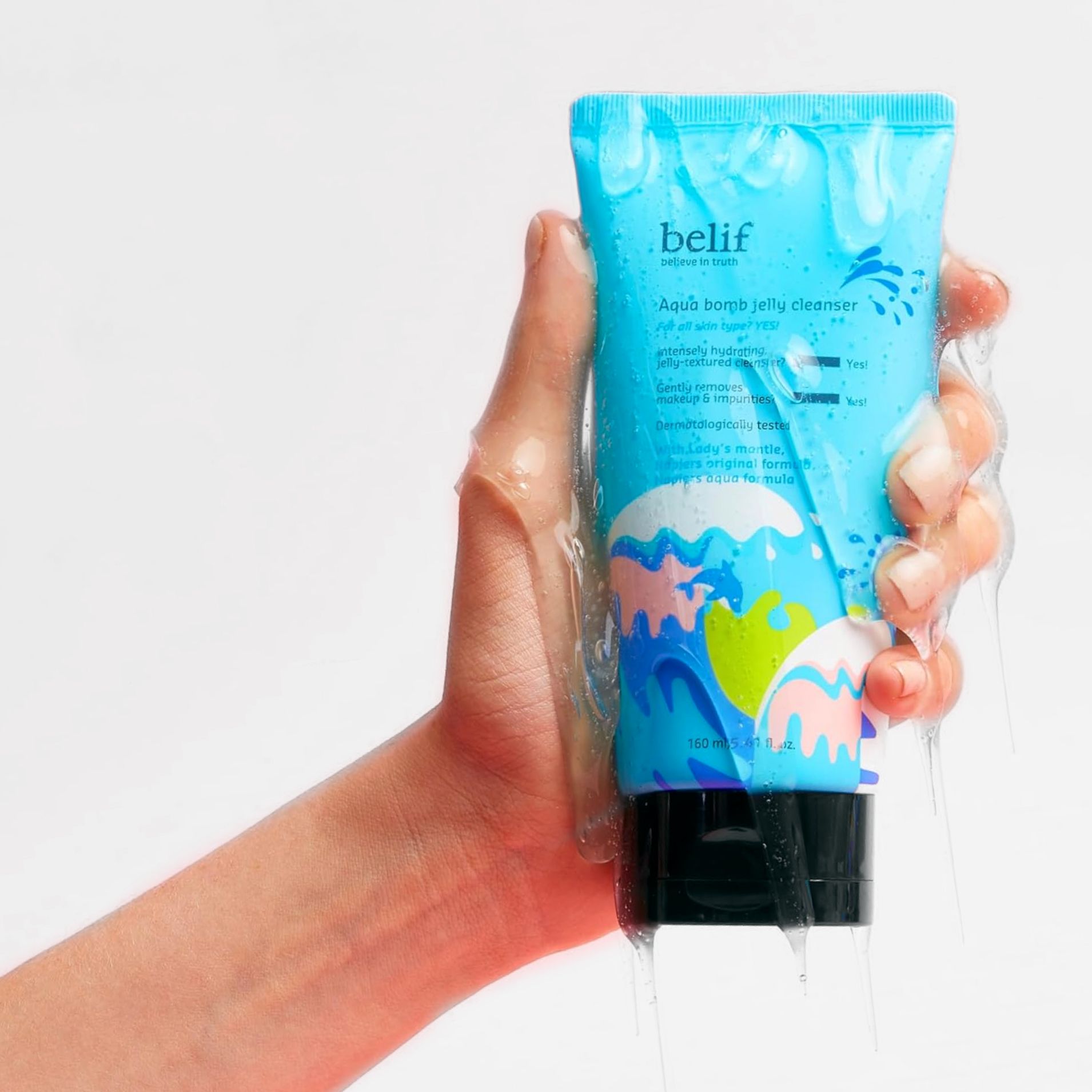 A hand holding a blue tube belif Aqua Bomb Jelly Cleanser