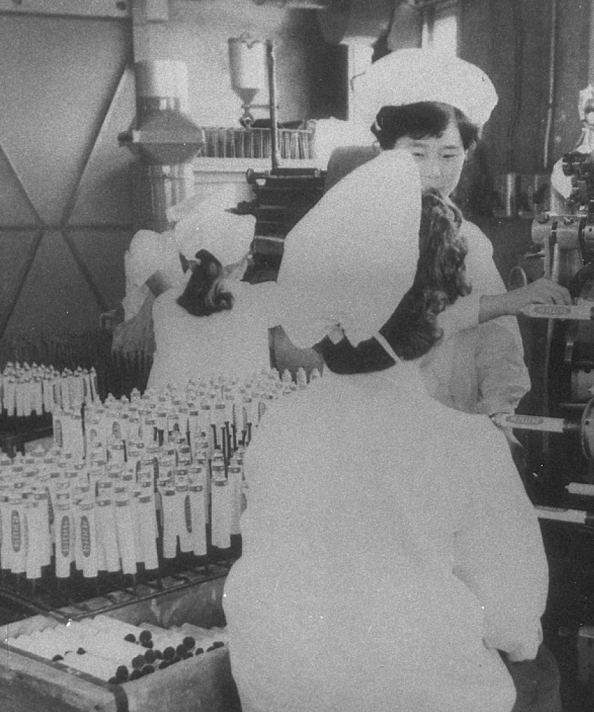 A black and white photo of Korean women working in cosmetics manufacturing 75 years ago for LG Beauty