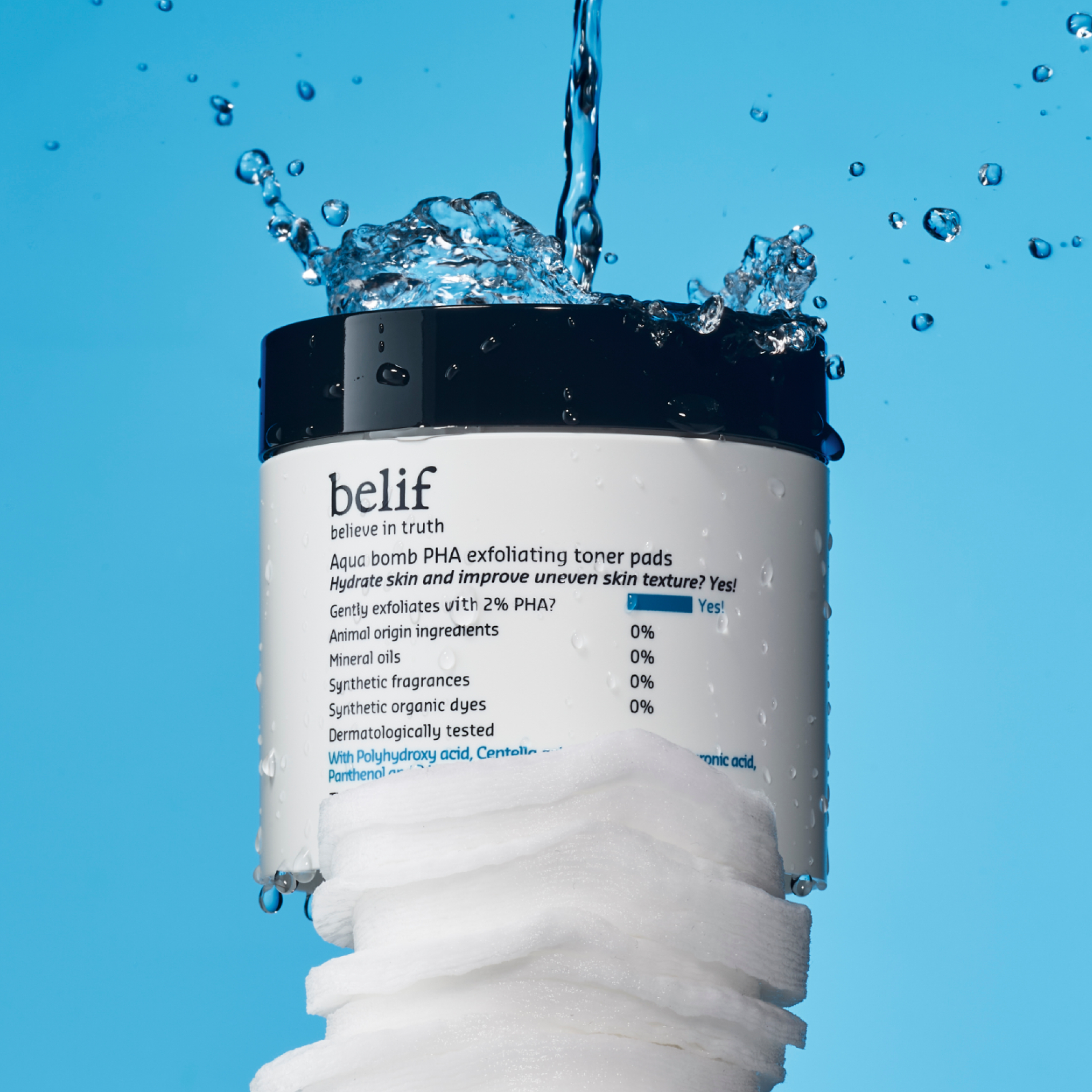 Water drips onto a container of belif Aqua Bomb PHA Exfoliating Toner Pads that sits on a stack of toner pads
