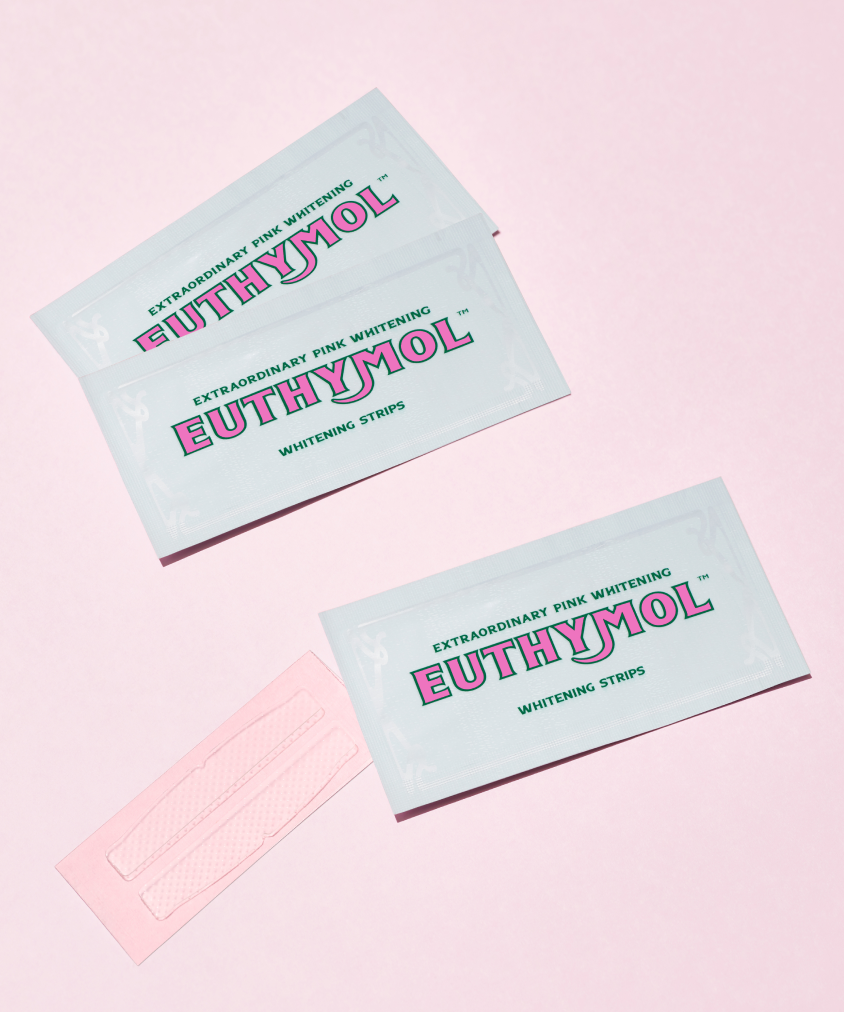Euthymol Whitening Strips lying on a pink surface