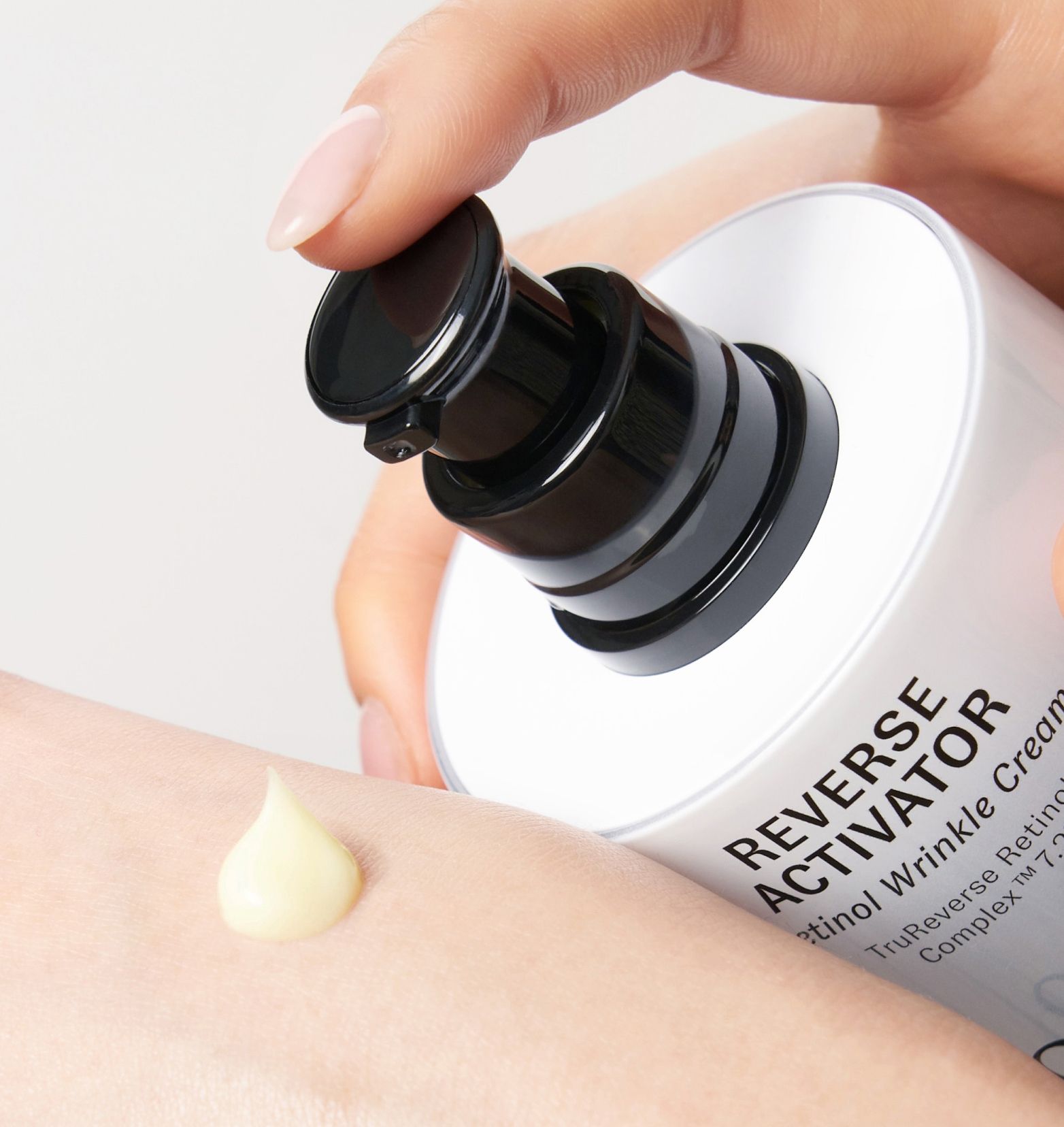 A drop of of Reverse Activator Wrinkle Cream being squeezed on skin surface.