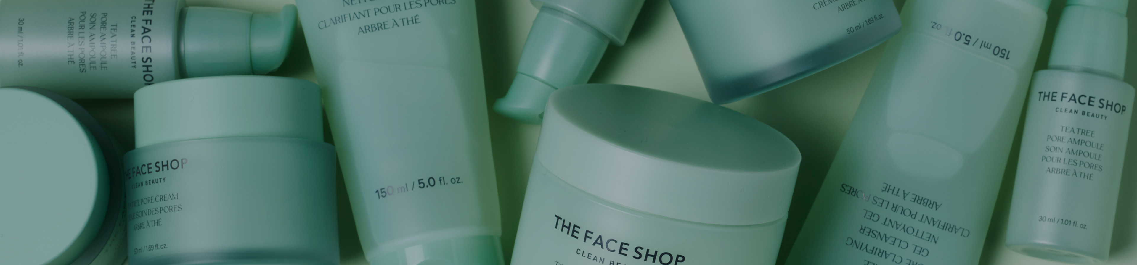 A bunch of light green jars and tubes of The Face Shop products lying around