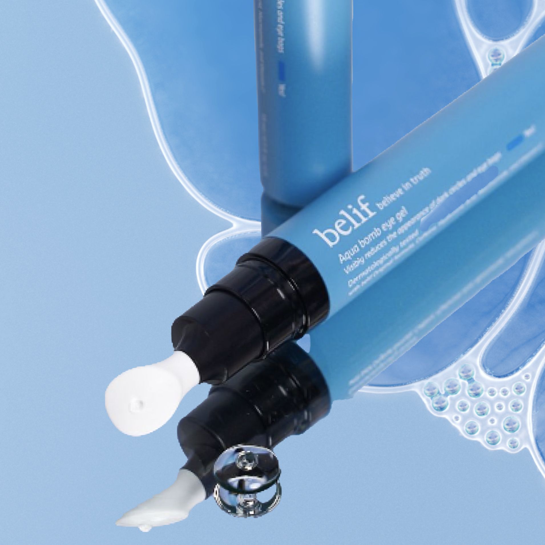 A tube of Belif Aqua Bomb eye cream is placed on a reflective surface next to its removed cap. The blue tube shows the product partially. A small amount of the cream is visible next to the tube.