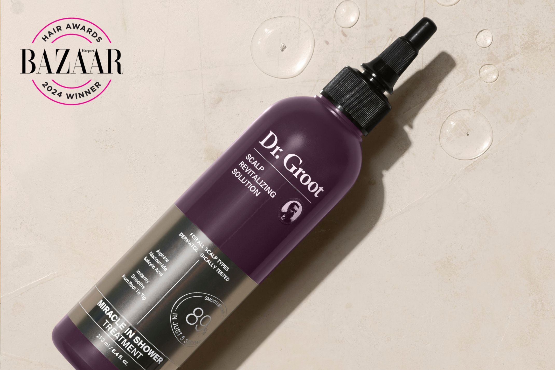 A purple bottle of Dr. Groot Miracle in Shower Treatment positioned on a textured surface, displaying a Harper's Bazaar 2024 Hair Awards Winner seal.