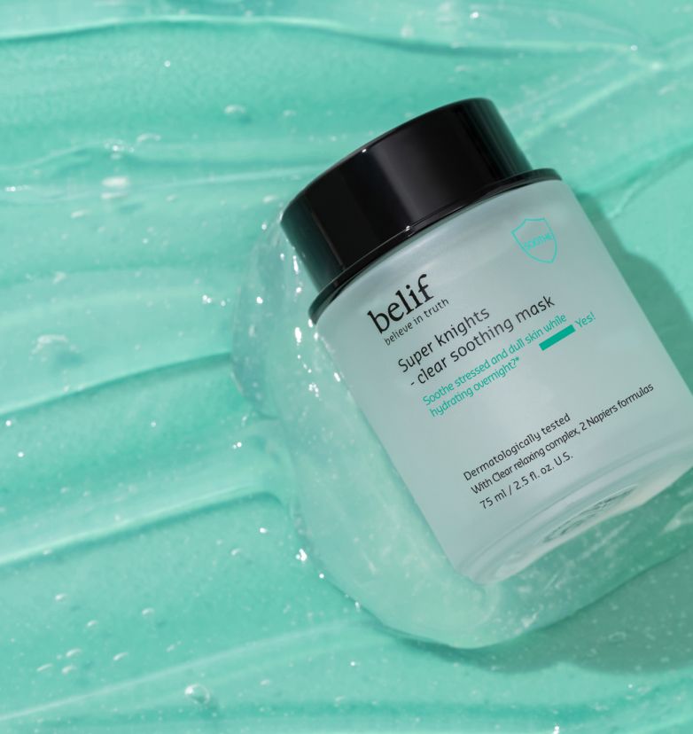 A jar of belif Super knights -Clear Soothing Mask lying in a light green spread of the mask.