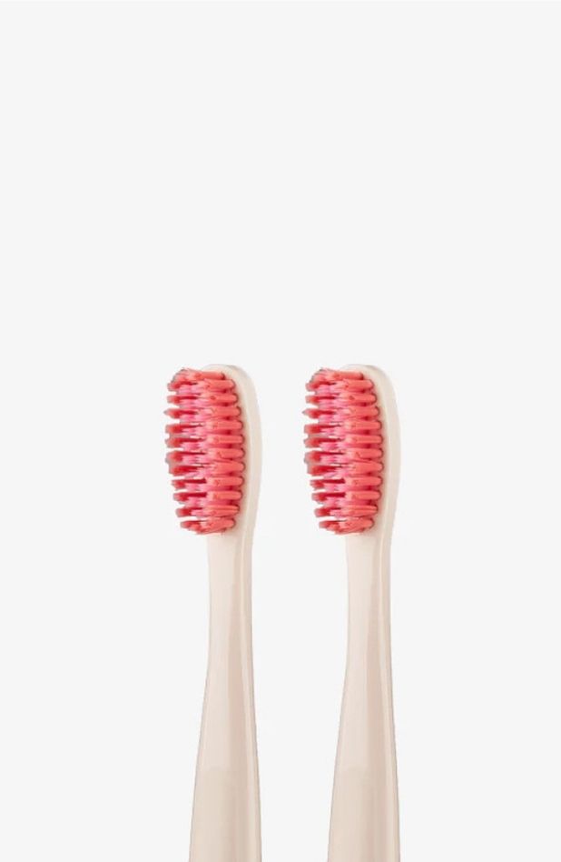 A closeup of two Euthymol Whitening Toothbrushes with pink bristles on a white background.