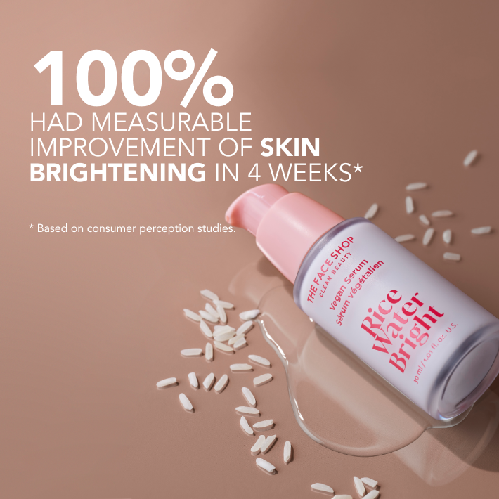 Image of a The Face Shop Rice Water Bright Vegan Serum on brown surface with texture spilled out surrounded by grains of rice,with text highlighting "100% improvement of skin brightening in 4 weeks" . Background in soft pink.