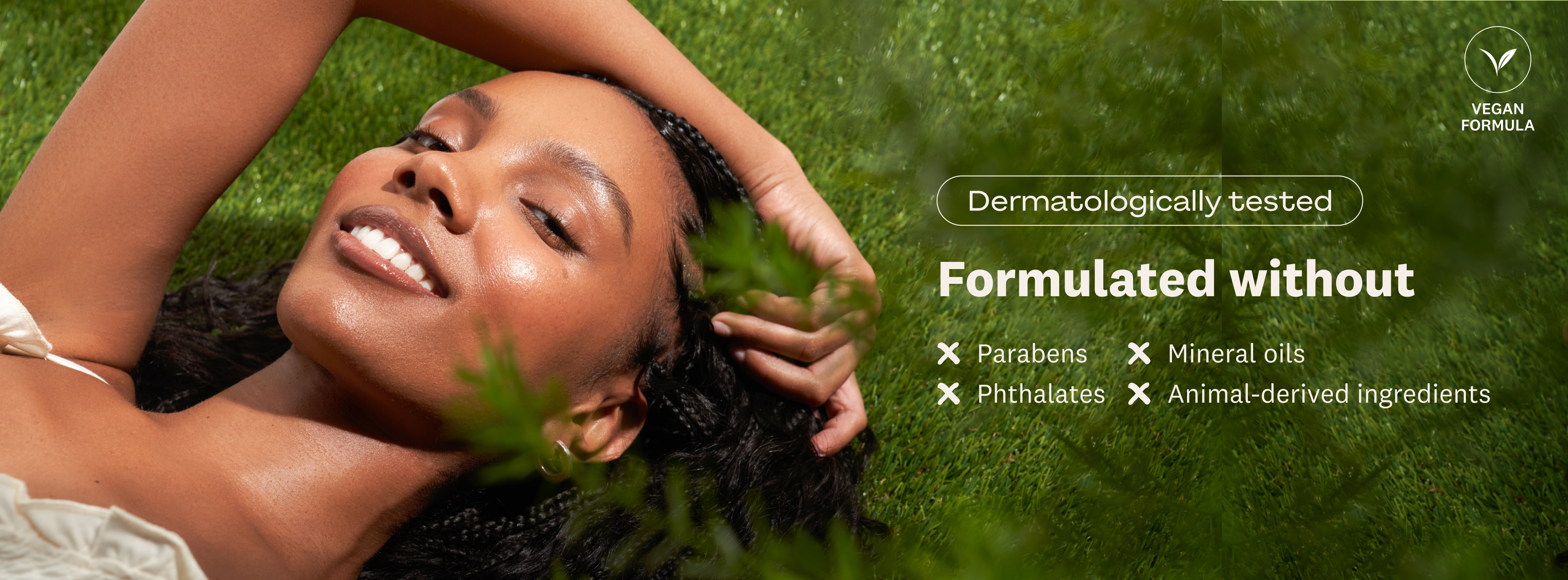 A smiling woman with glowing skin lies on grass, next to text promoting a "Vegan Formula" that is "Dermatologically tested" and free from parabens, mineral oils, phthalates, and animal-derived ingredients.