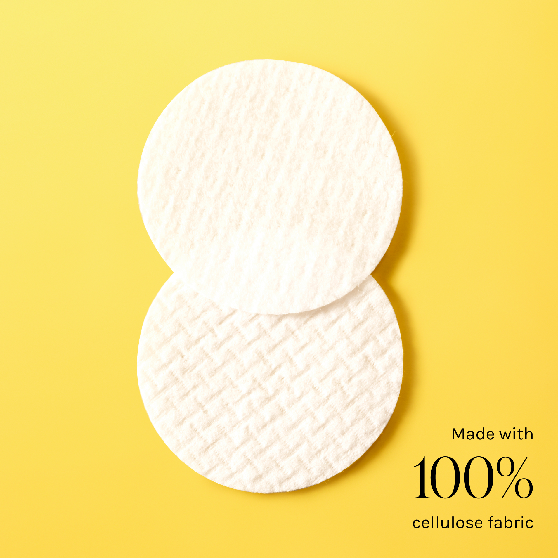 Two pads of OHUI Miracle Toning Water pads on a bright yellow background with text ''Made with 100% cellulose fabric'' in the corner of the photo.