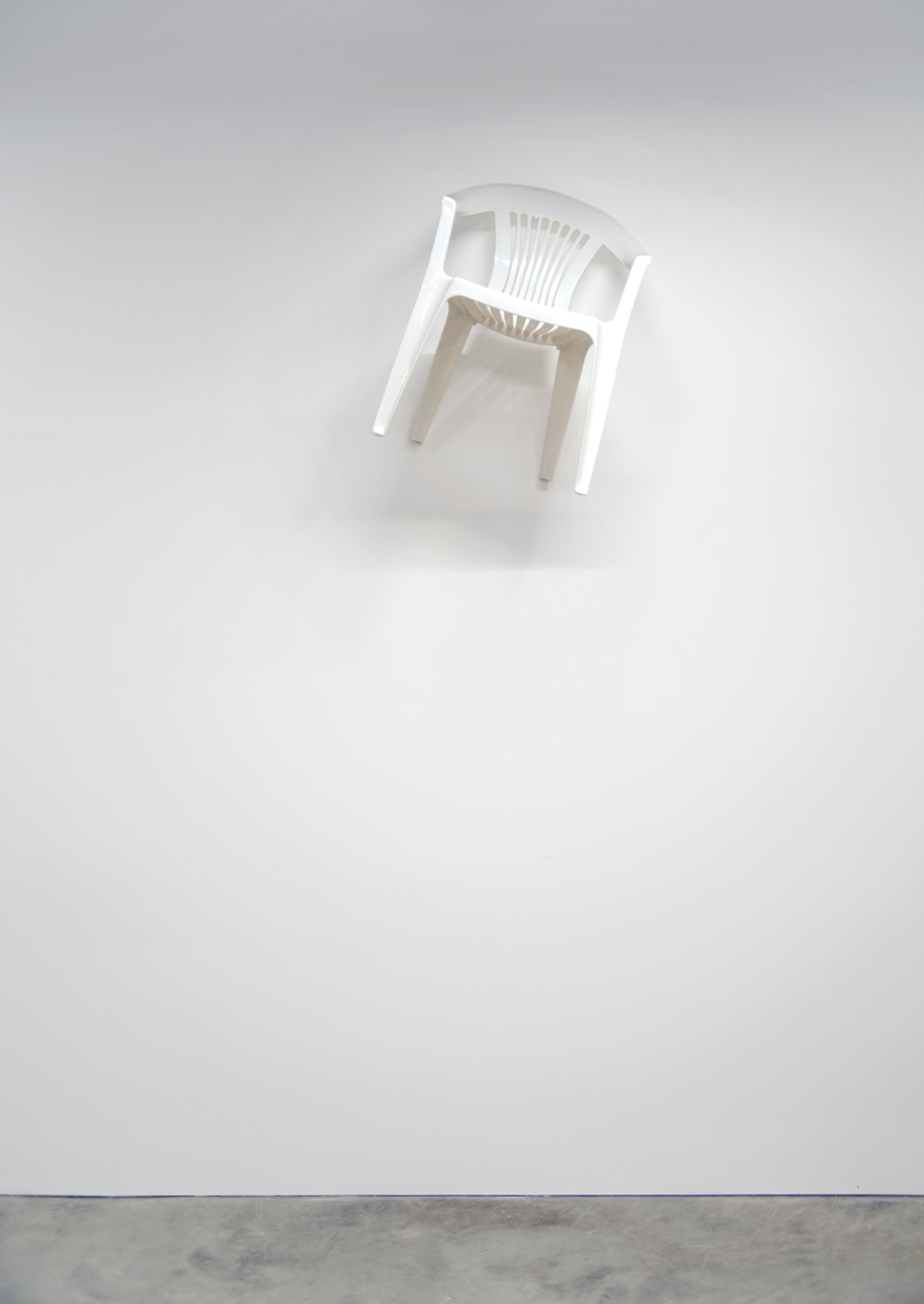 Stefanos Mandrake, Plastic Chair (2016). Found white plastic chair on wall.