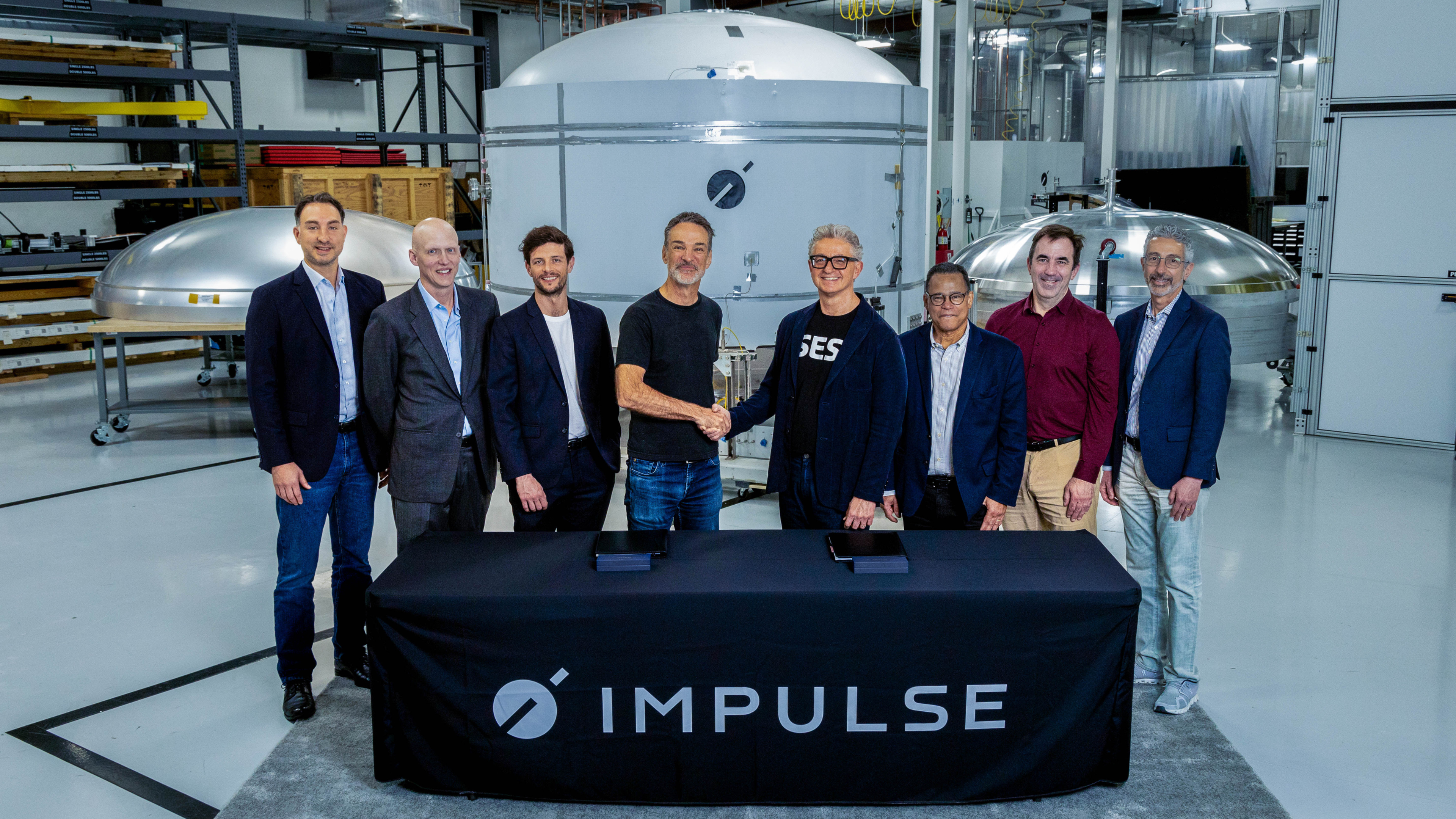 Impulse and SES executives sign a contract in front of Helios