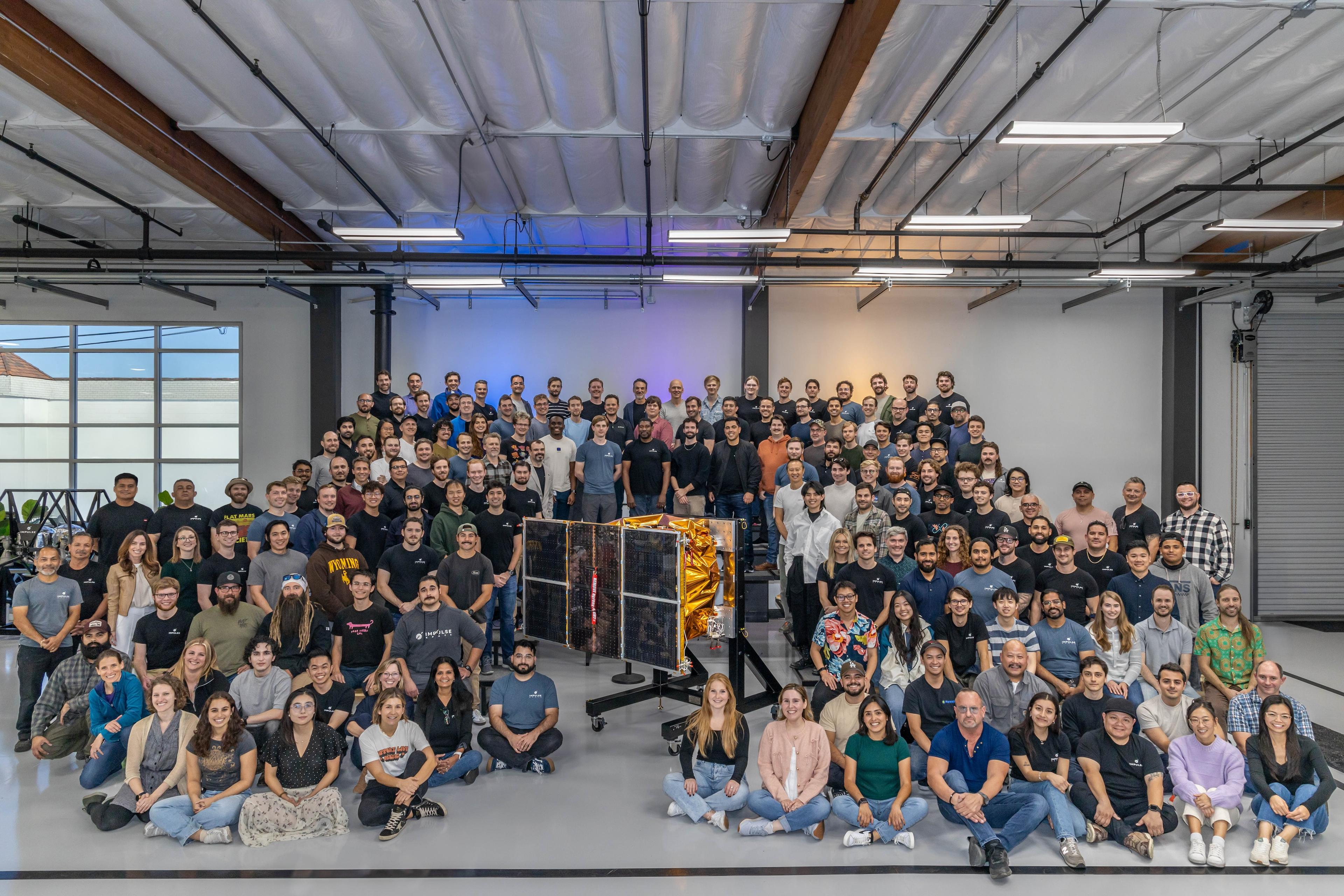 A team photo of Impulse Space employees around our Mira vehicle.