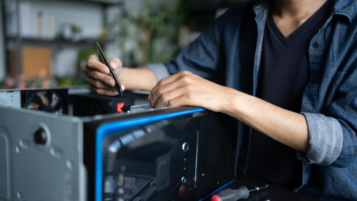Technician removing a component from an open server chassis with a screwdriver