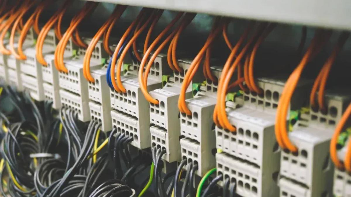 Close-up of industrial terminal blocks with orange and black wiring