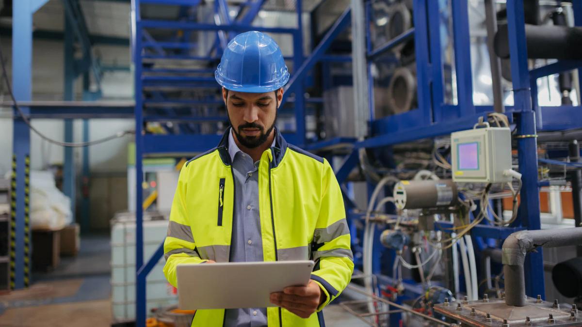 Process operator reviewing live production data on a tablet on the plant floor.