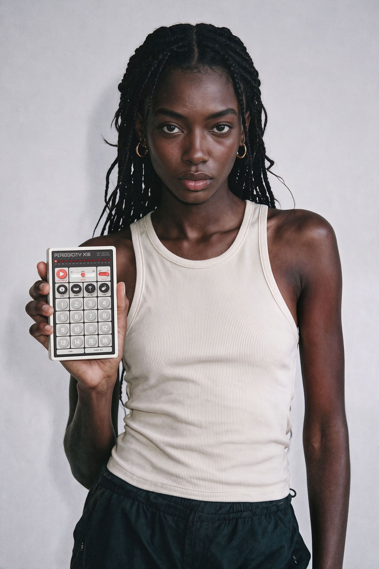 Model holding the X16 hardware drum machine and sequencer