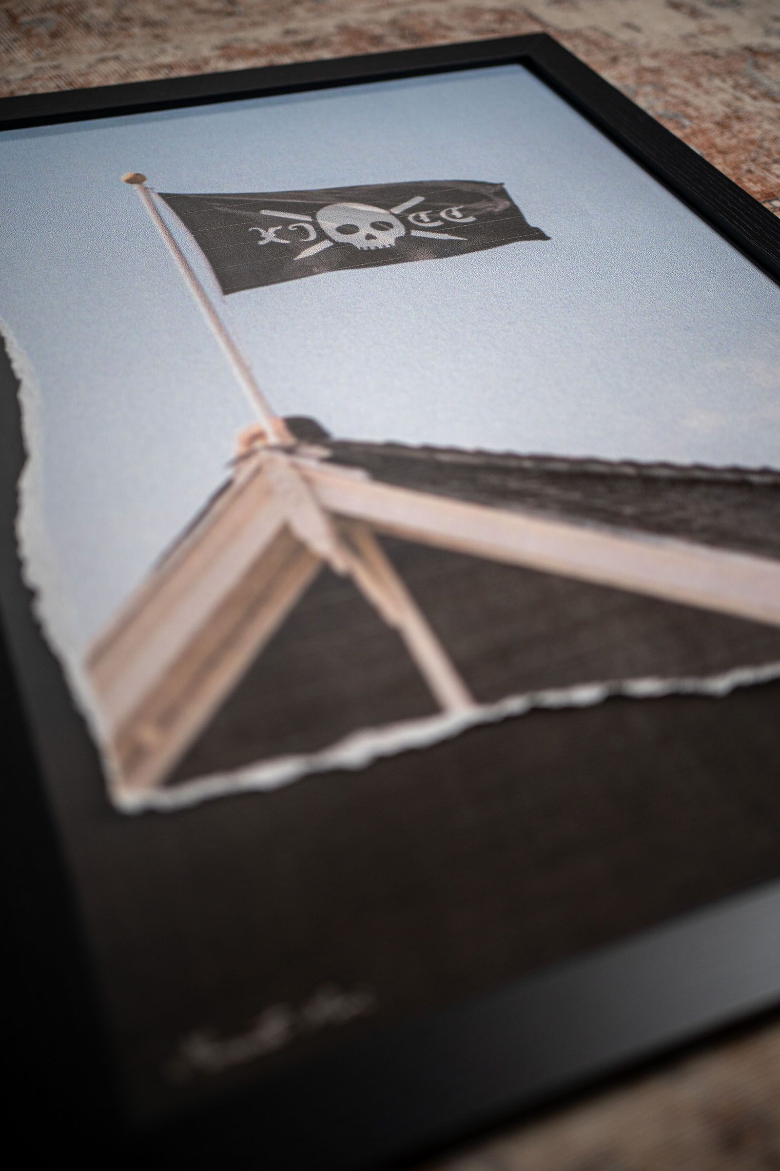 Angled close-up of a framed photograph of an Eleven Cricket Club flag above a building.