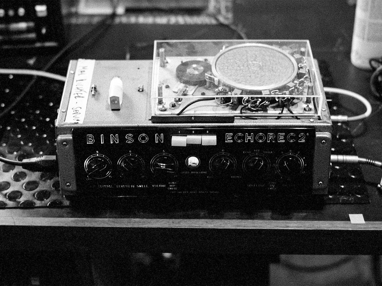 Black-and-white close-up of a Binson Echorec tape-echo unit with its circular mechanism exposed.