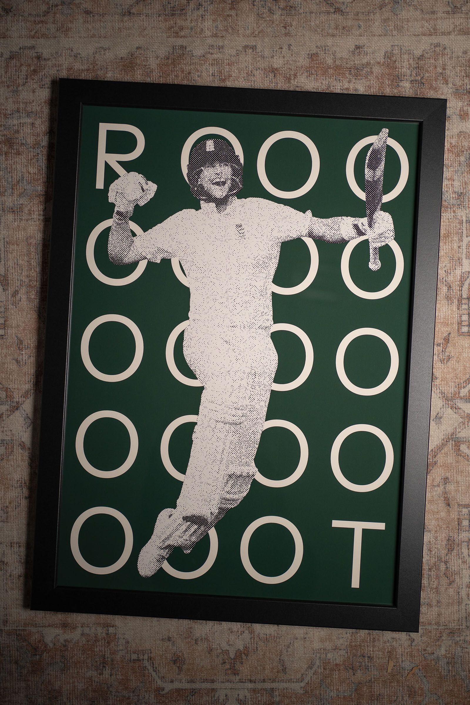 Framed green cricket poster with an illustrated batter surrounded by repeated circular lettering.