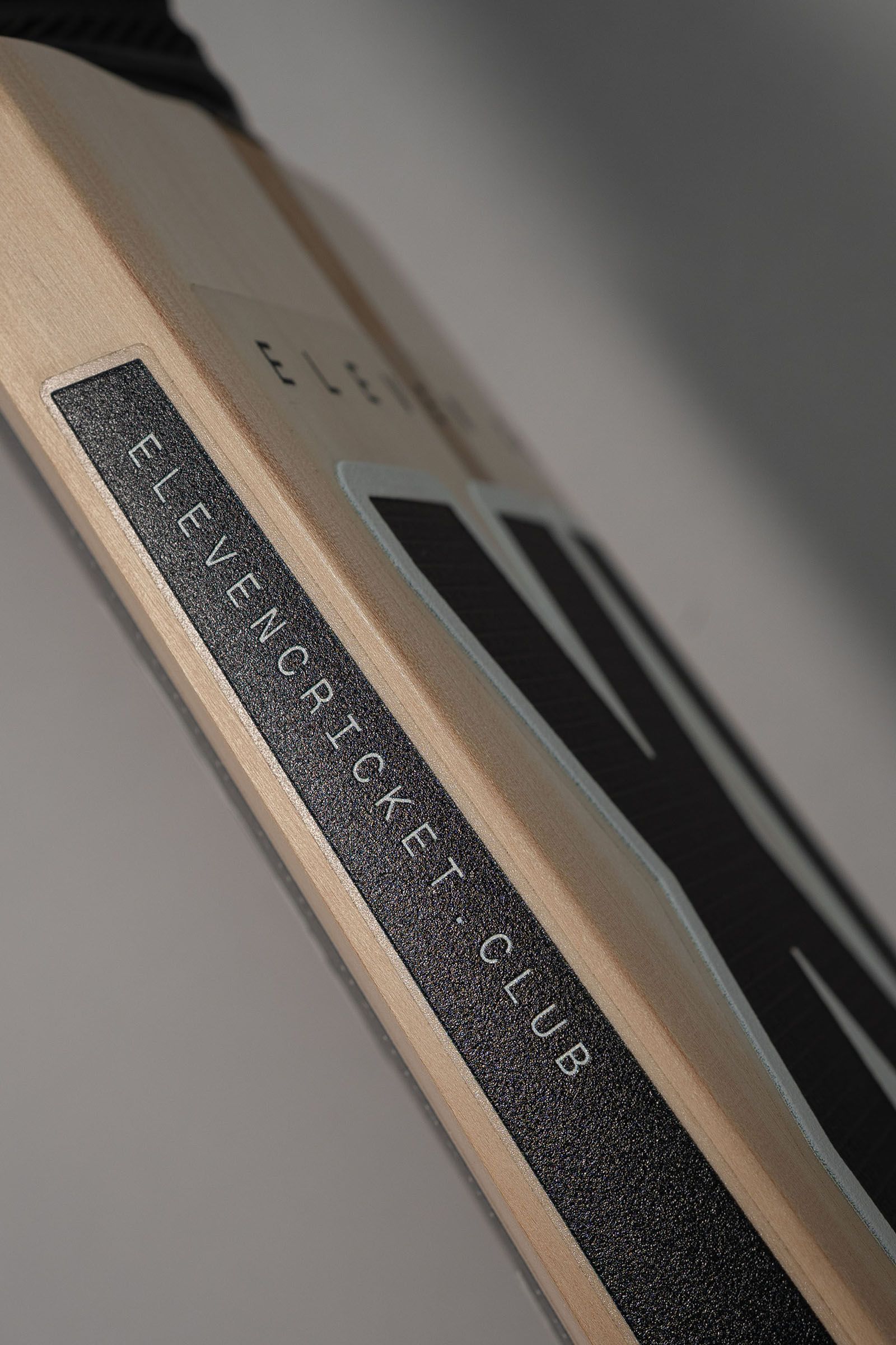 Close-up of the side of an Eleven Cricket Club bat, showing its Finest English Willow label.