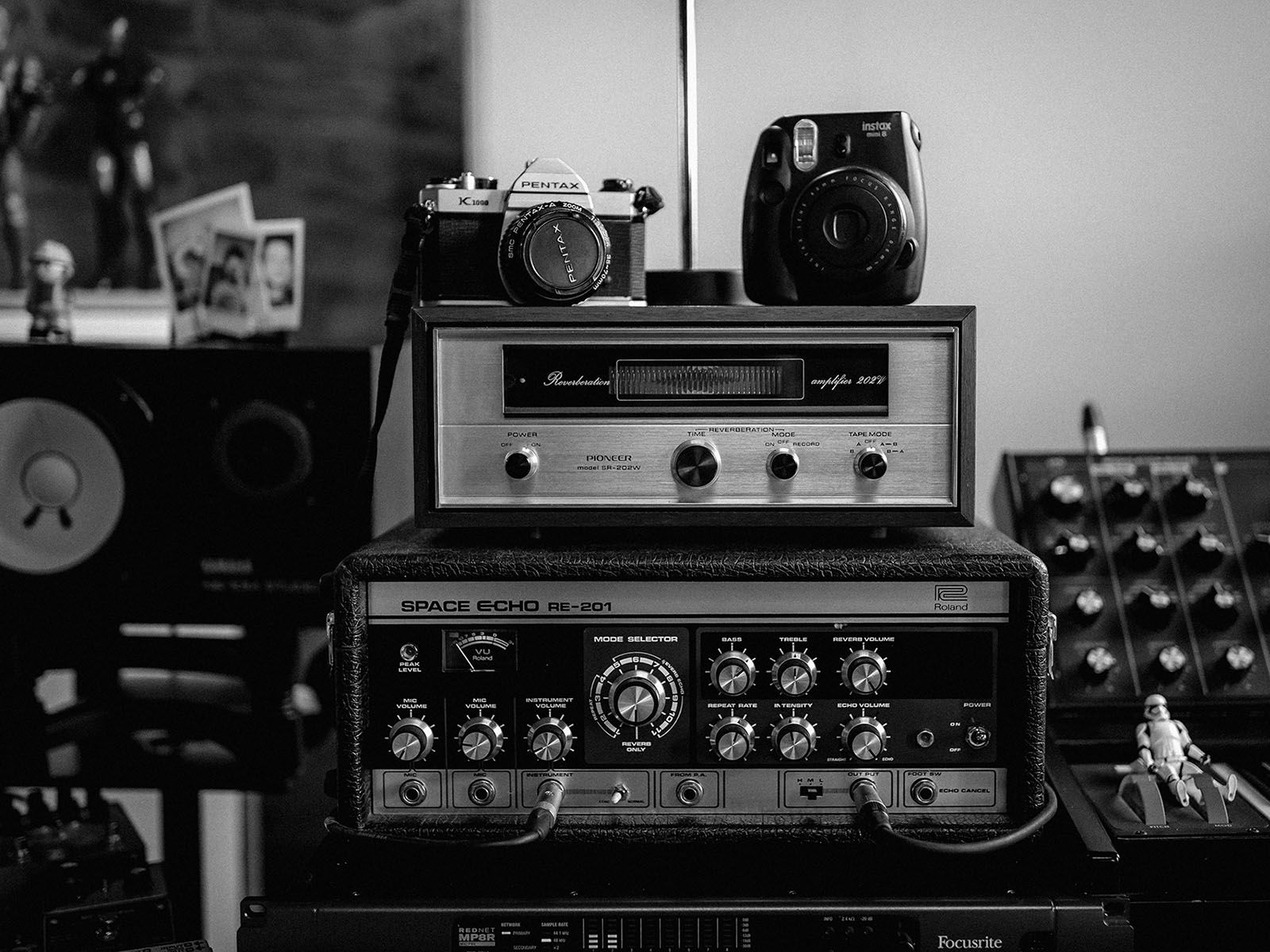 Black-and-white photograph of cameras, a reel-to-reel tape recorder and audio equipment in a studio.