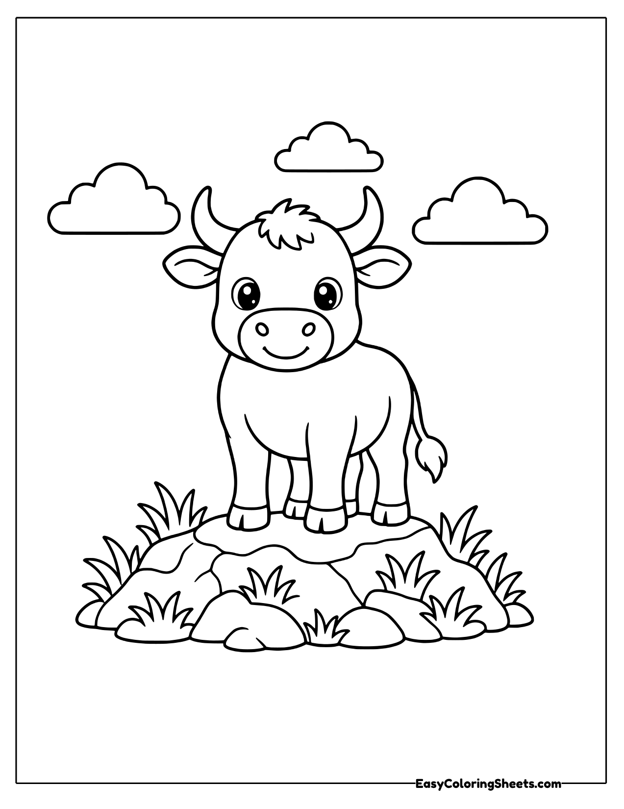Bull standing on a grassy rock ridge